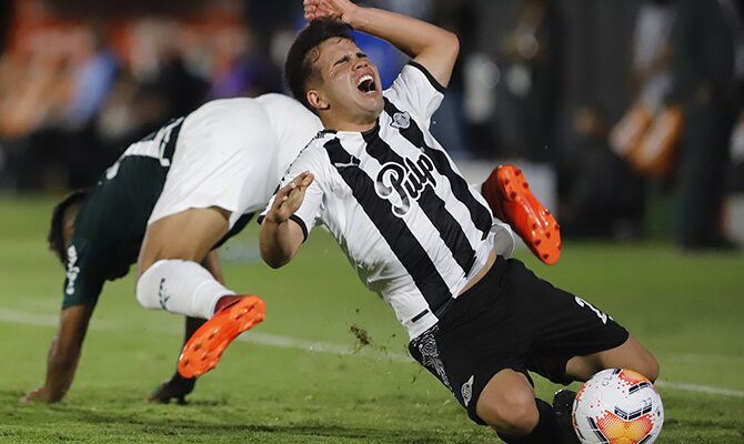 Hugo Martínez del Libertad cae de forma aparatosa ante el balón. Cuotas y picks del Libertad vs Universidad Católica.