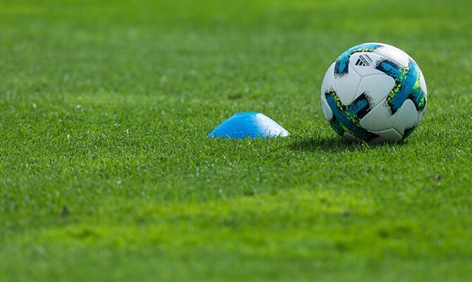 El balón sobre el césped delante de un cono azul. Cuotas Deportivo La Guaira vs Cerro Porteño.
