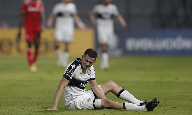 Luis Cáceres del Olimpia se duele en el suelo de un golpe. Cuotas Olimpia vs Deportivo Táchira.