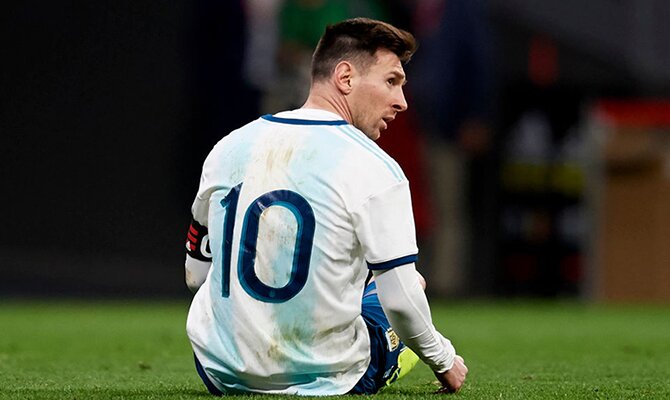Lionel Messi sentado en el césped. Cuotas Argentina vs Chile, Eliminatorias Copa Mundial Conmebol.