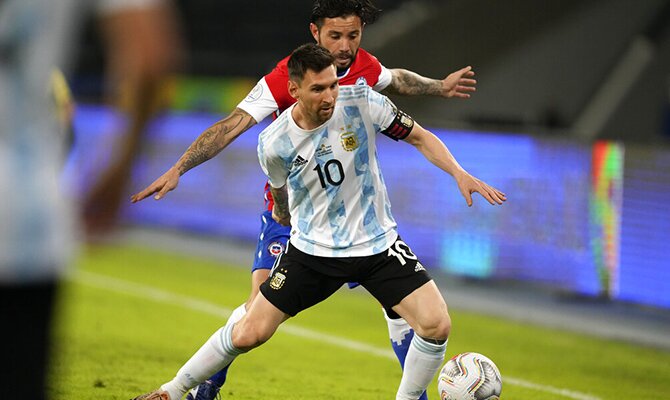 Lionel Messi protege el balón ante un rival. Cuotas Argentina vs Paraguay, Copa América 2021.