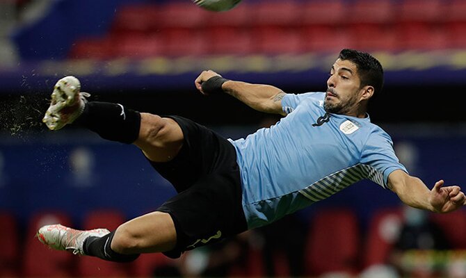 Luis Suarez tratando de ejecutar una volea en el aire. Cuotas y picks Uruguay vs Paraguay.