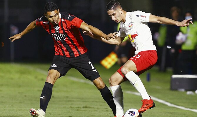 Daniel Bocanegra y Bruno Conceicao pelean por un balón. Apuestas, Libertad vs Bragantino.