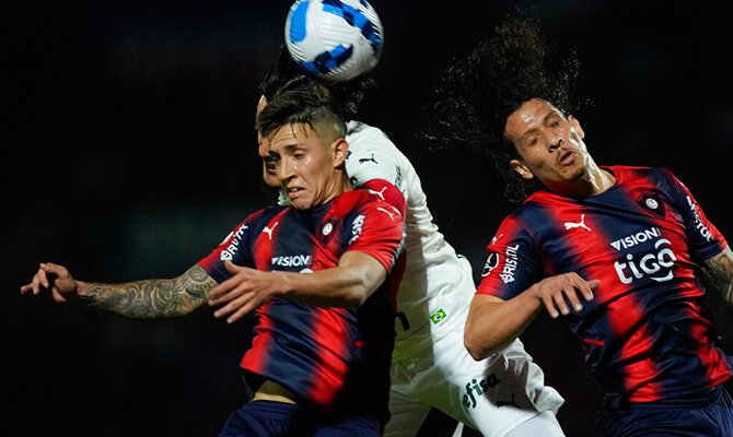 Alan Rodriguez y William Riveros de Cerro Porteno buscan cabecear el balon