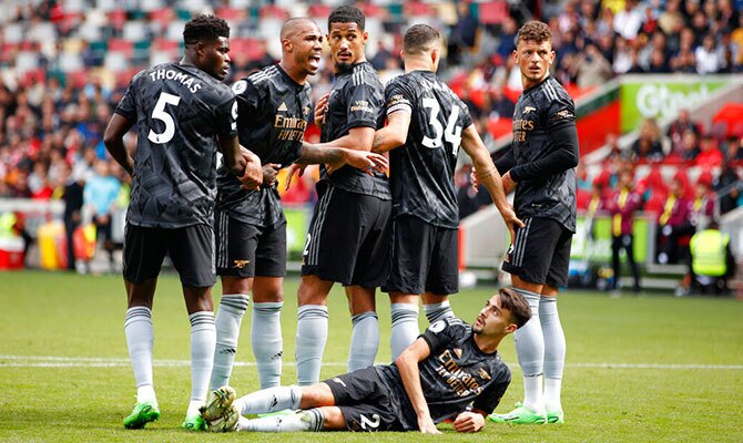 Jugadores del Arsenal forman una barrera en partido ante el Brentford