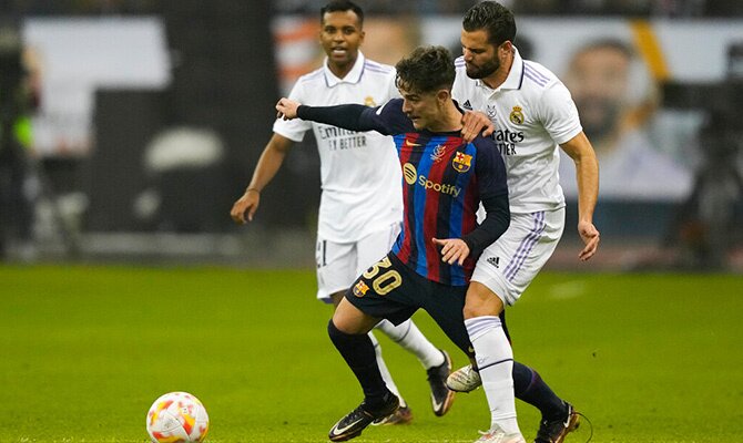 Gavi del Barcelona y Nacho del Real Madrid disputan el balon en El Clasico