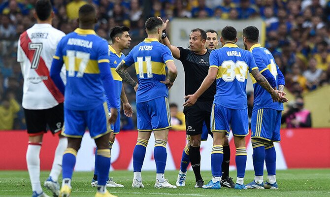 Jugadores de Boca Juniors reclaman al arbitro en el superclásico ante River en 2022