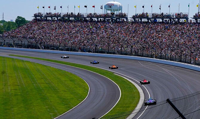 Varios vehículos pasan una curva en las 500 Millas de Indianapolis 2022