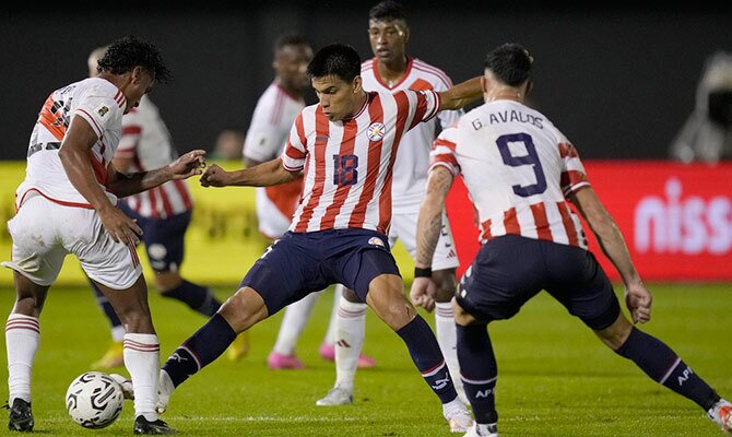 Diego Gomez de Paraguay disputa un balon en partido contra Peru