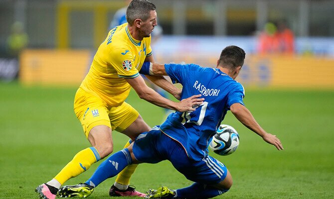 Giacomo Raspadori de Italia protege el balon ante Eduard Sarapi de Ucrania